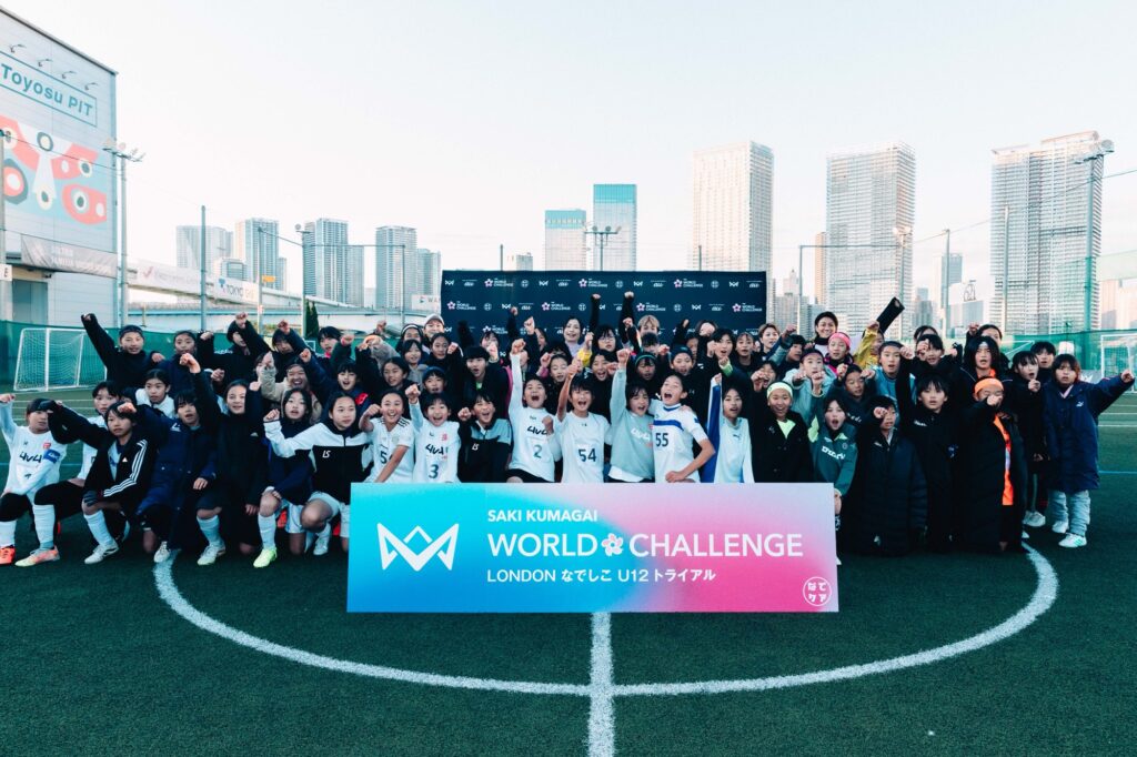 WORLD CHALLENGE LONDONの看板前に集まる大人数のグループ写真