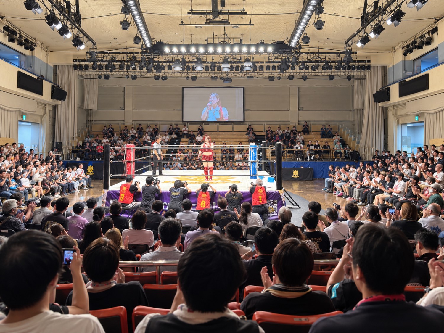 満員の観客に囲まれた女子プロレス興行の会場