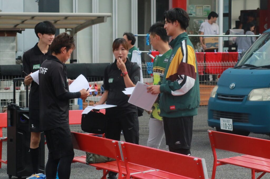 大会運営スタッフが書類を確認しながら打ち合わせる様子