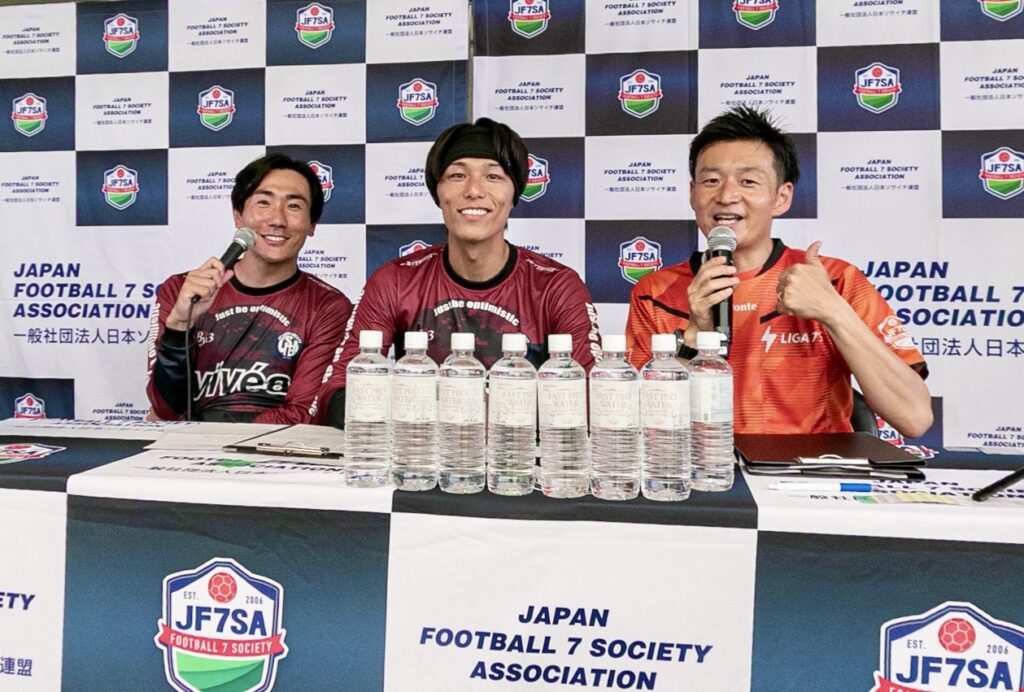 協賛企業のボードを背景に行われるスポーツ大会の記者会見