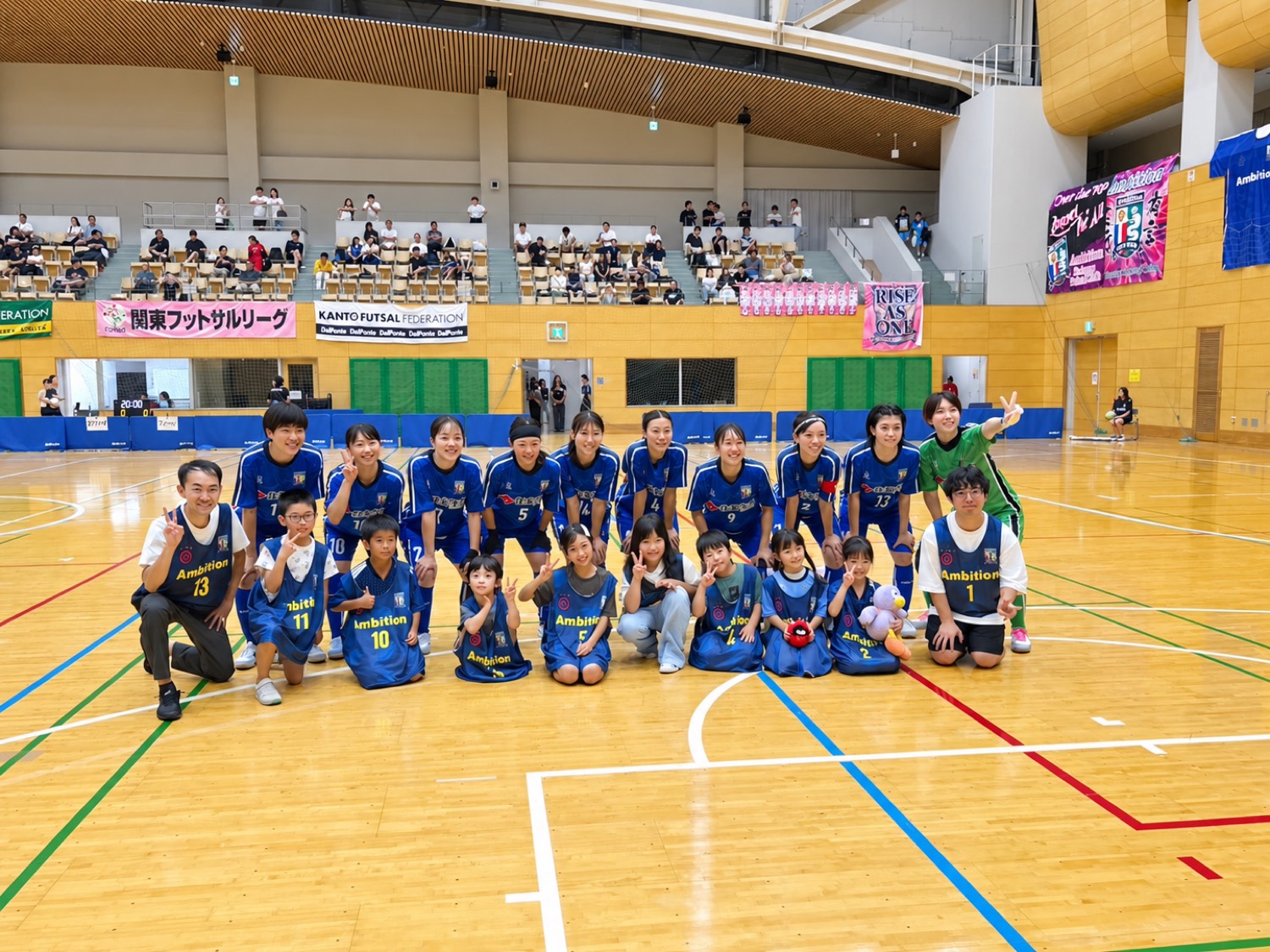 試合前にコートで記念撮影する選手と子どもたち