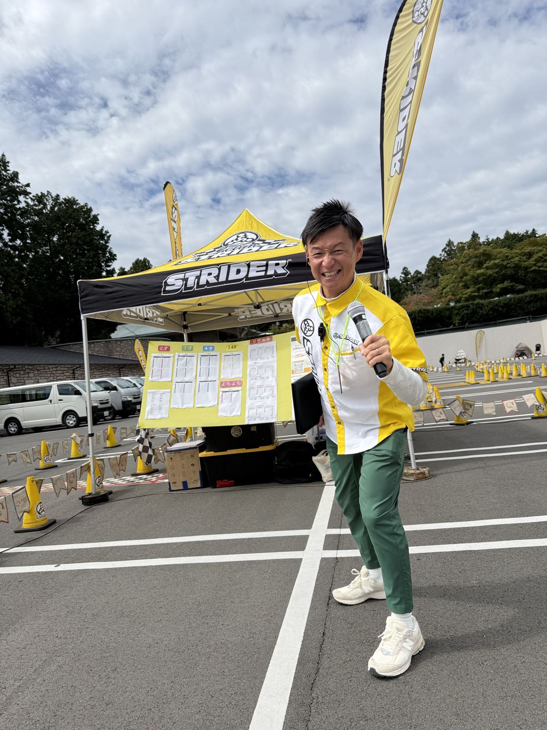 STRIDERのシャツを着て、マイクを手に笑顔で構えるMCおのしん