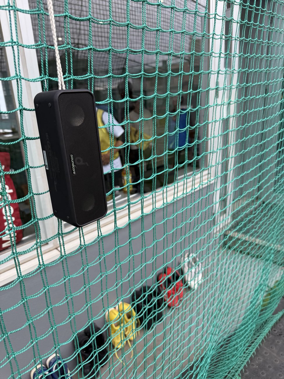 フットサルコートの防球ネットに取り付けられたスピーカー